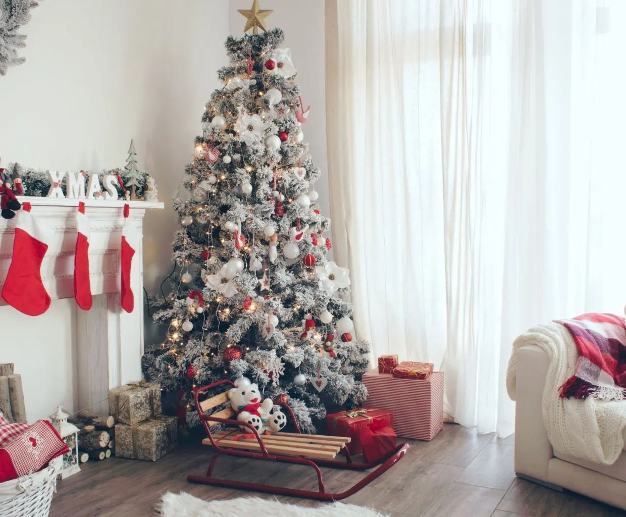 Árbol de Navidad decorado junto a una chimenea con calcetines y regalos