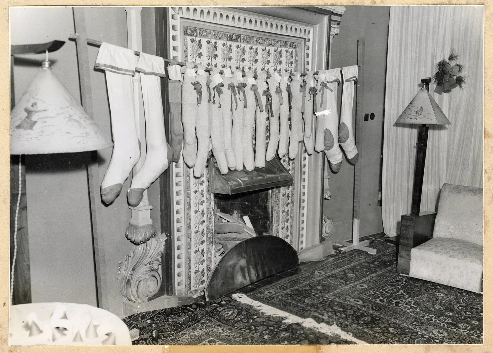 Foto en blanco y negro de 1943 con una fila de calcetines navideños colgados sobre una chimenea