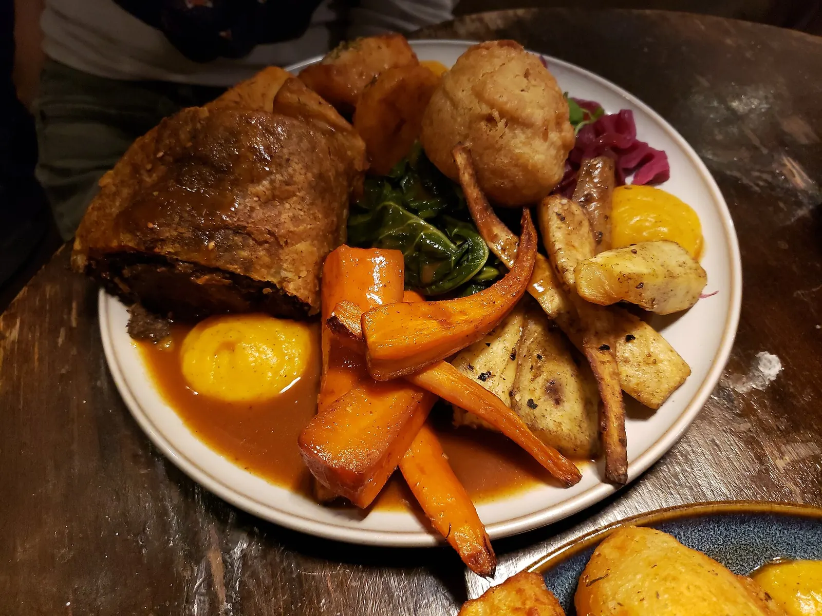 Plato de wellington vegano de remolacha con zanahorias y chirivías asadas, espinacas y salsa