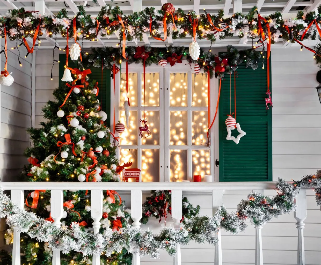 Porche de casa decorado con guirnaldas navideñas, luces y un árbol de Navidad