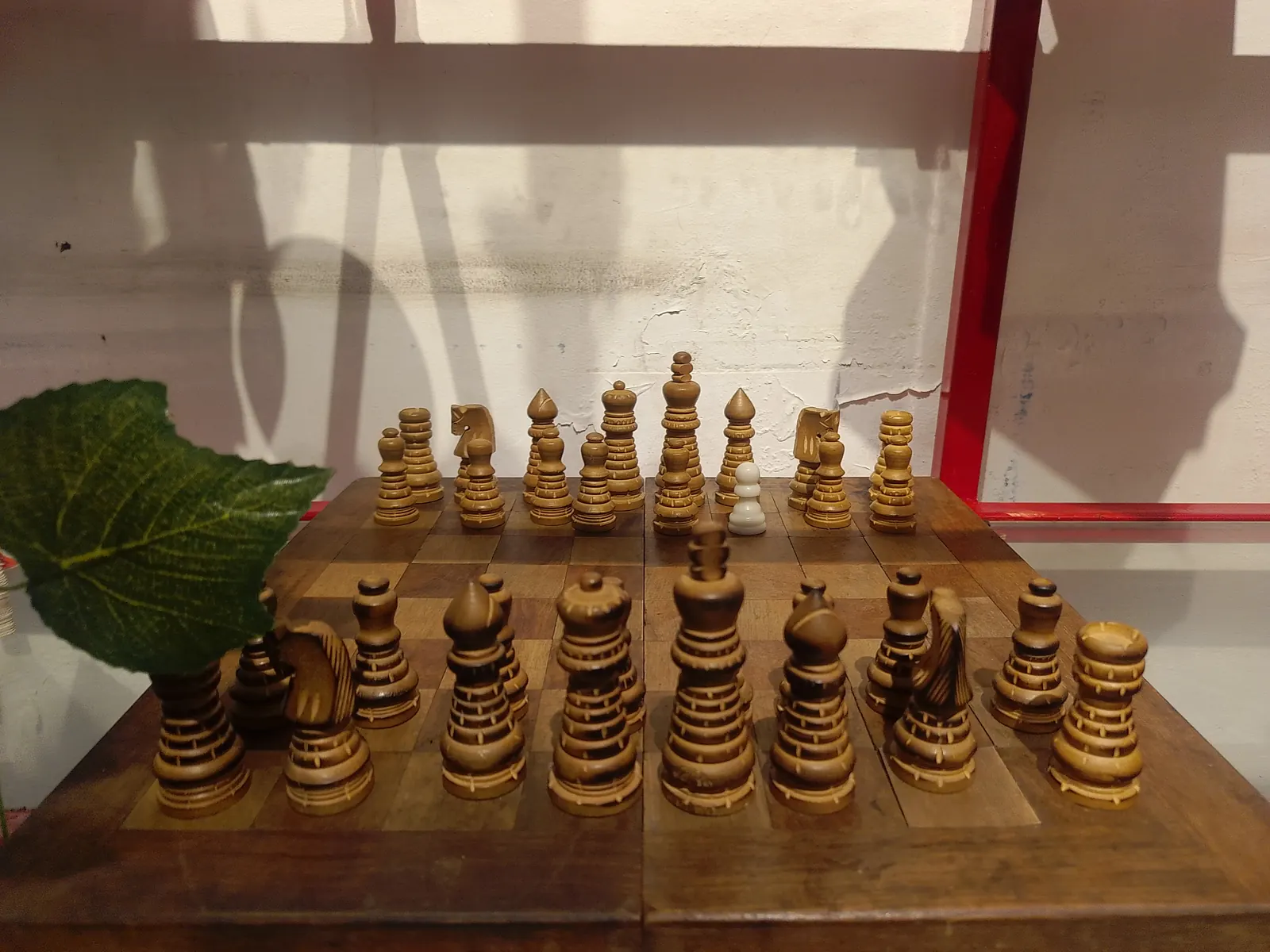 Tablero de ajedrez de madera con piezas talladas a mano colocadas para empezar la partida