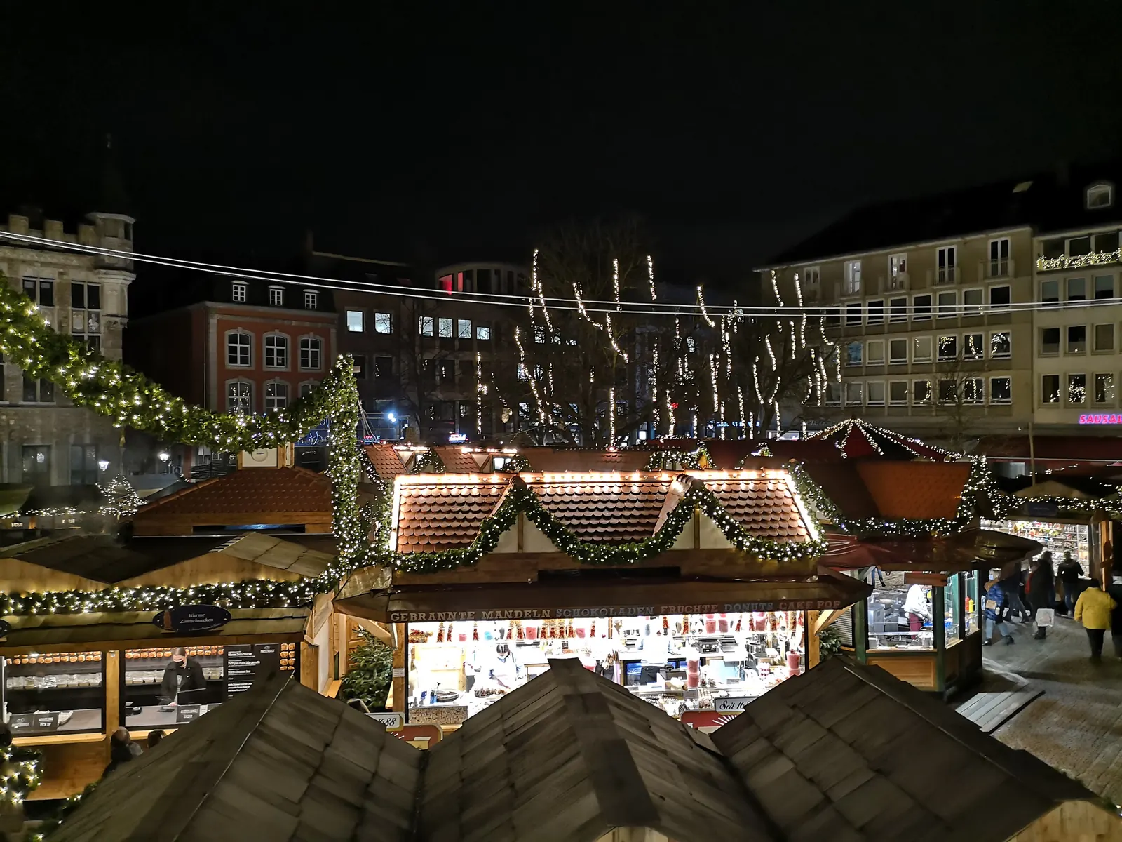 Casetas de madera con guirnaldas y luces en el mercado navideño de Aquisgrán (Alemania) de noche