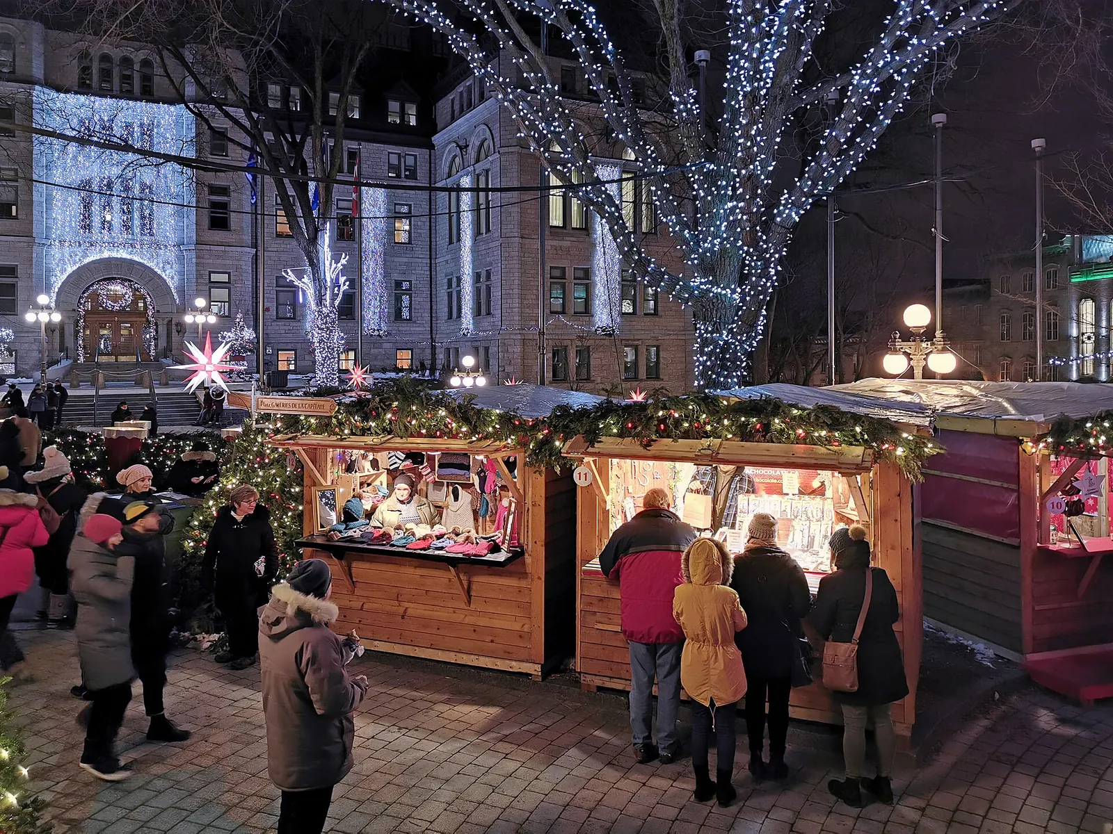 Mercado de Navidad de noche en la ciudad de Quebec, con casetas de madera, guirnaldas y árboles con luces