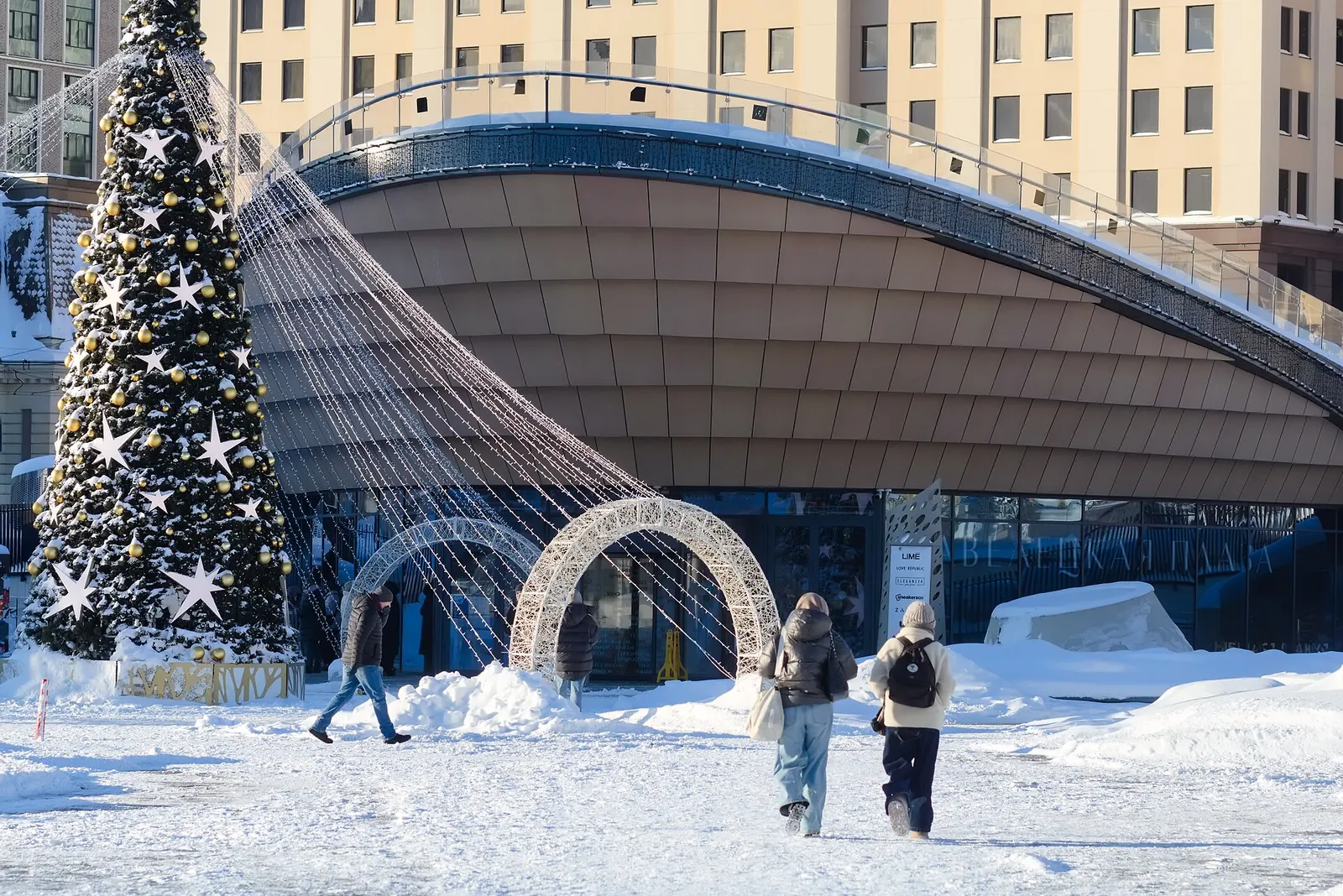Abeto de Año Nuevo con estrellas y arcos de luces en la plaza Paveletskaya de Moscú cubierta de nieve