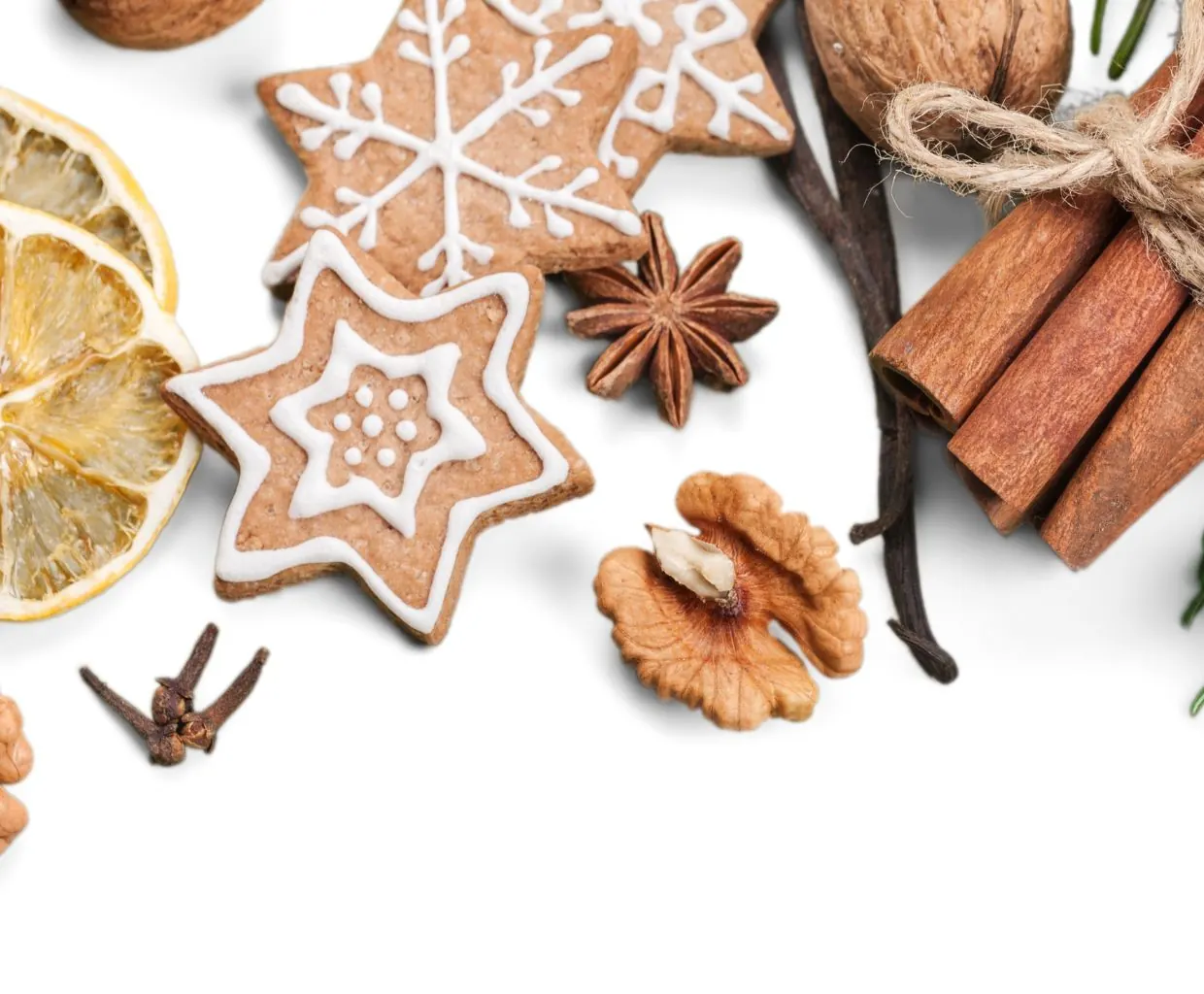 Especias navideñas sobre fondo blanco: canela en rama, anís estrellado, clavo, una galleta de estrella y nueces