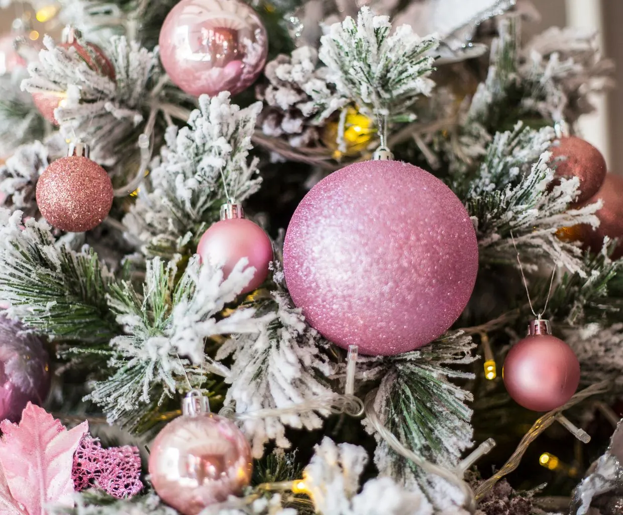 Árbol de Navidad nevado con bolas rosas y plateadas de estilo aesthetic