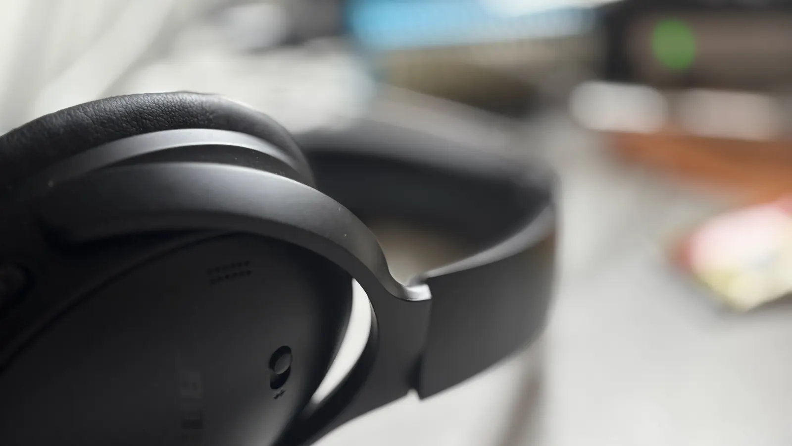 Primer plano de unos auriculares de diadema negros sobre un escritorio