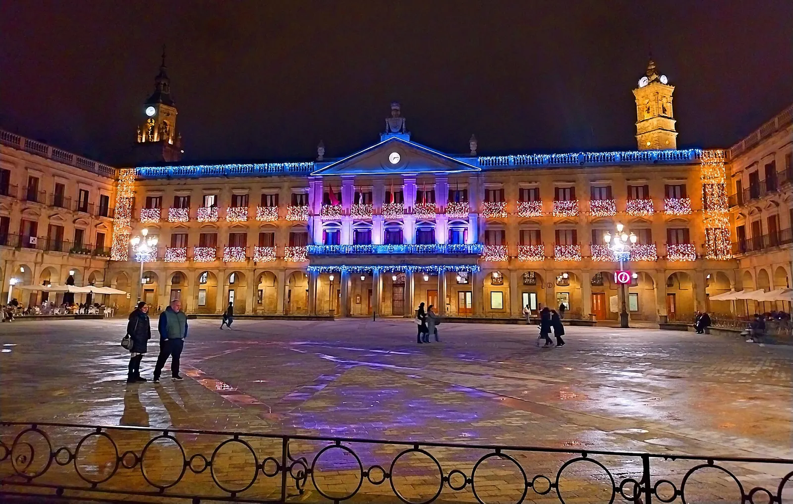 Plaza de España de Vitoria-Gasteiz de noche, con el ayuntamiento y los soportales iluminados por luces navideñas